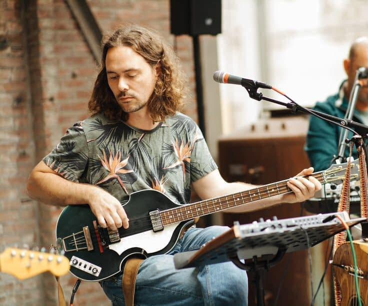 Mark speelt basgitaar tijdens een optreden