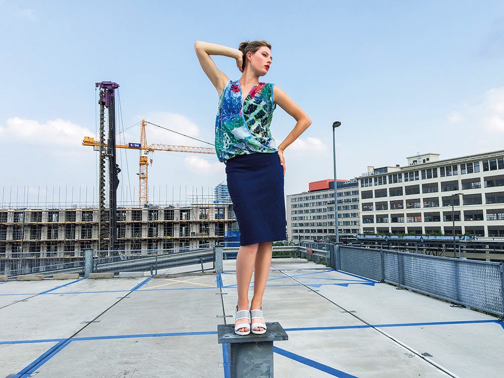 Modeshoot op een dak met bouwkranen op de achtergrond